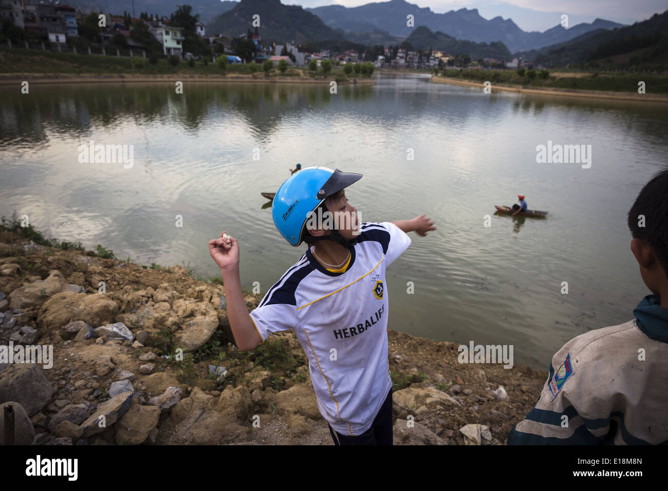 Un garçon lance des pierres à petit lac situé près de la ville de Bac Ha Banque D'Images