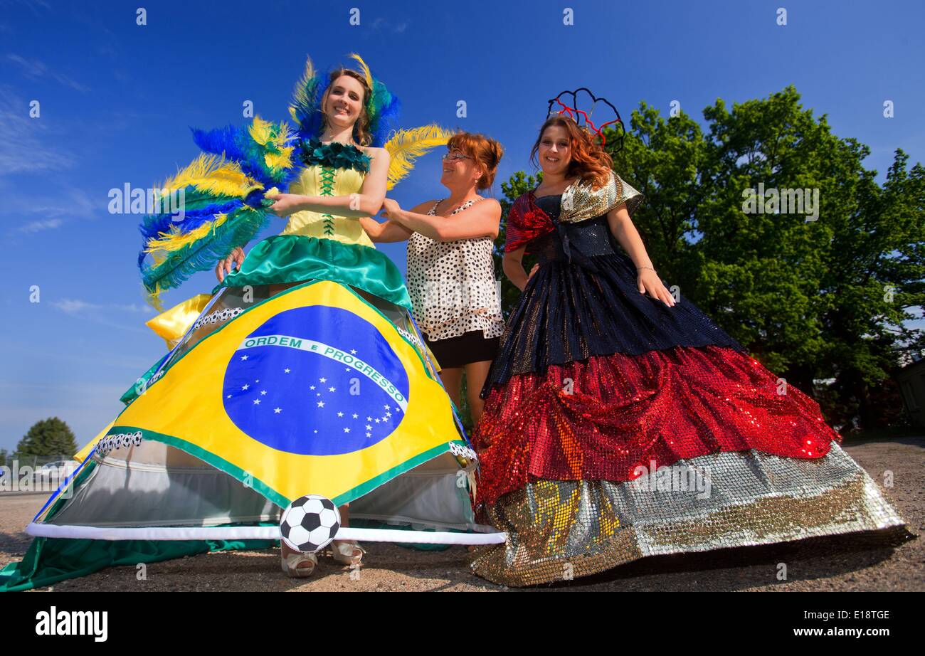 Luebeck, Allemagne. 26 mai, 2014. Fashion designer Manuela Offenborn (C)  redresse la robe de bal, avec les couleurs du Brésil et présenté par Annika  Silkeit (L), que le modèle Felic Koc (R)