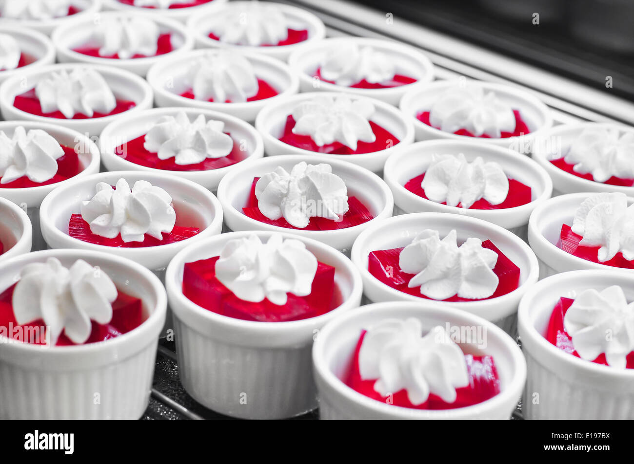 Red jelly à fouetter la crème dans la coupe blanc Banque D'Images