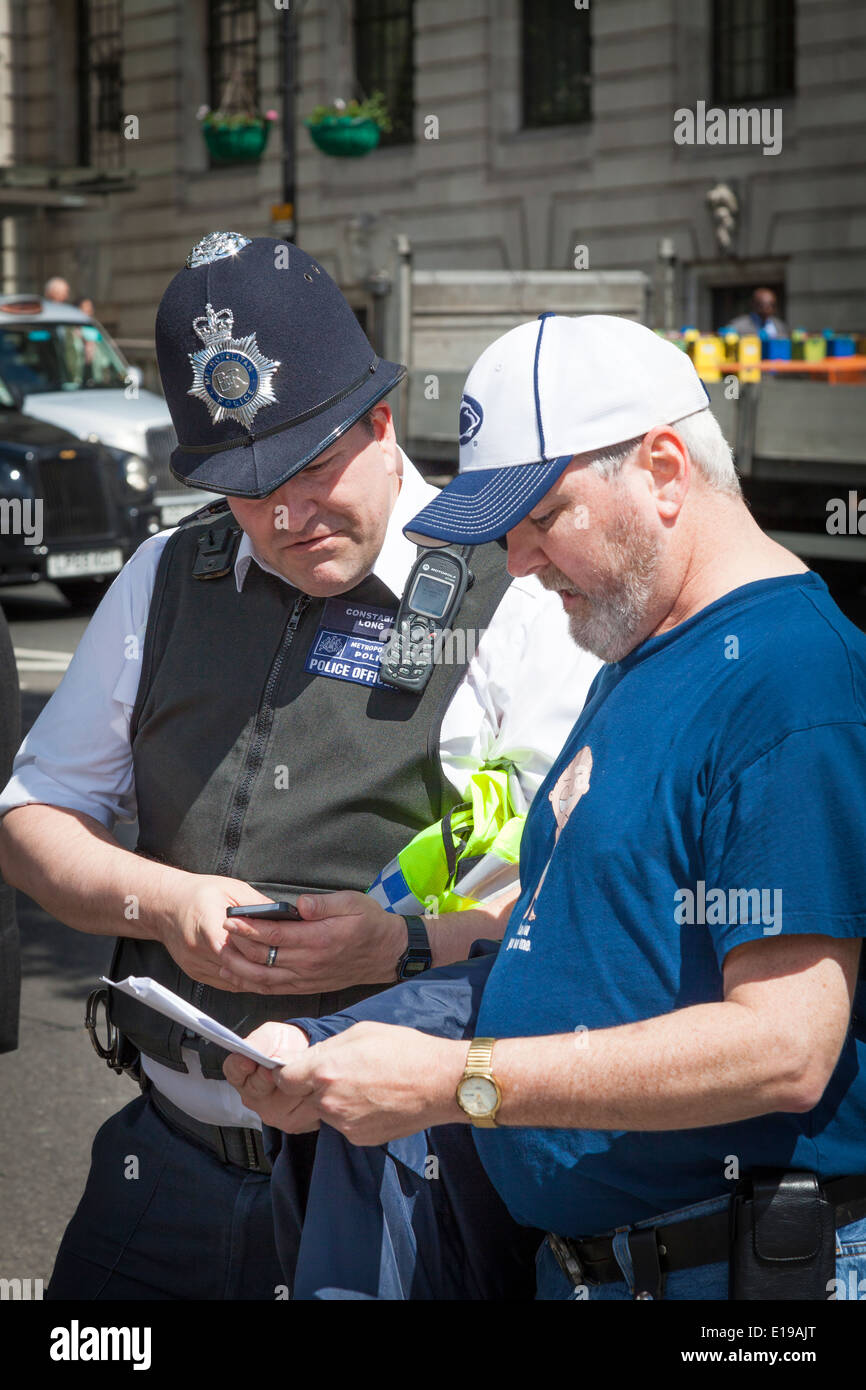 Friendly London Bobby aide les touristes avec les directions. Banque D'Images