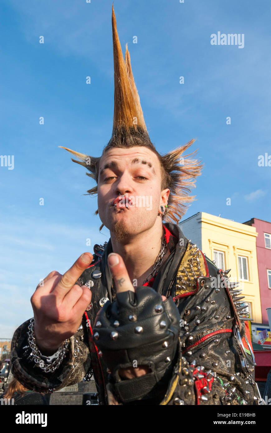 Punk avec les cheveux hérissés de basculer le doigt de Mohican, Camden Town, London, UK Banque D'Images
