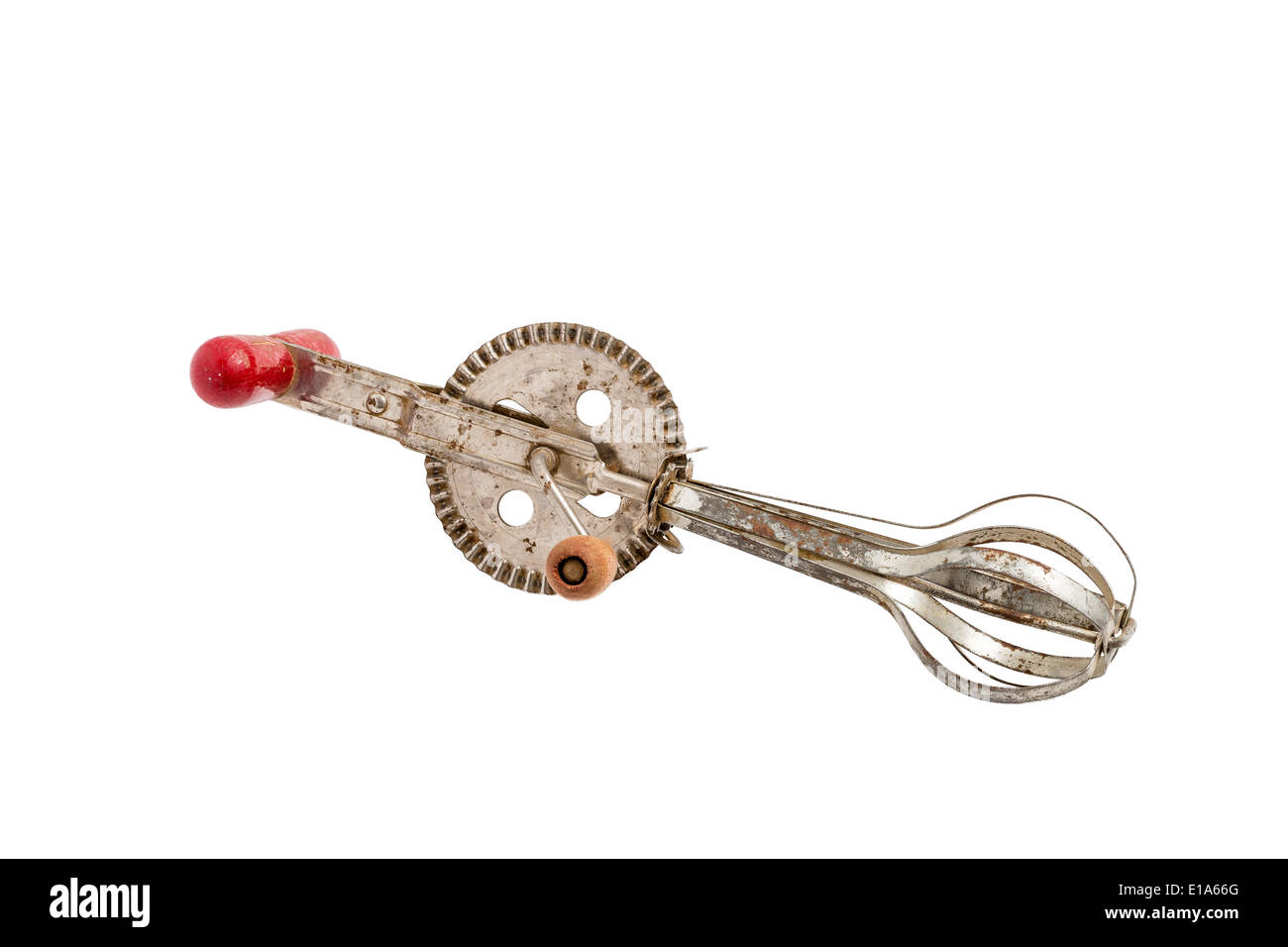 Batteur à oeufs antiques avec un manche en bois rouge sur un solide fond blanc Banque D'Images