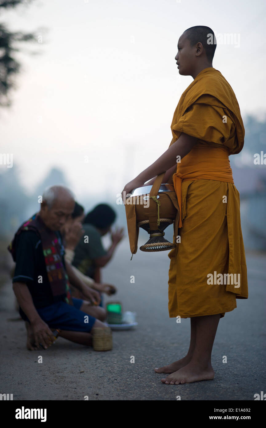 Les moines de Pha Sikhottabong, la collecte de l'aumône au lever du soleil, les villageois de Tha Kaek, Laos. Banque D'Images