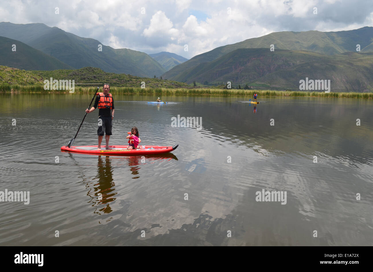 Un homme Stand Up Paddle (SUP) avec ses enfants sur la Laguna, Huacarapay dans près de Cusco, Pérou Banque D'Images