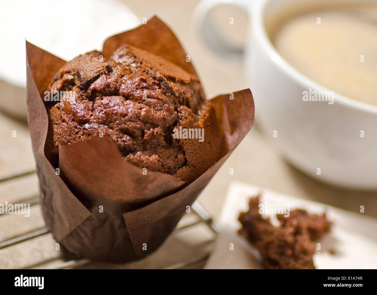 Un muffin au chocolat noir fraîchement cuits au four avec du café. Banque D'Images