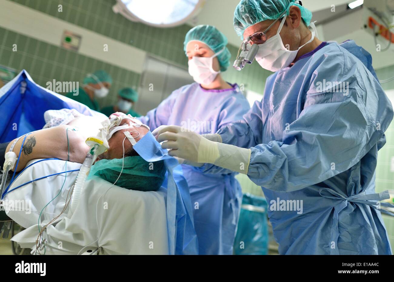 Directeur médical adjoint Joachim Maurer (R) prépare un patient pour la chirurgie dans une salle d'opération à l'Université Clinique ORL Mannheim, Allemagne, 22 mai 2014. Photo : UWE ANSPACH/dpa Banque D'Images
