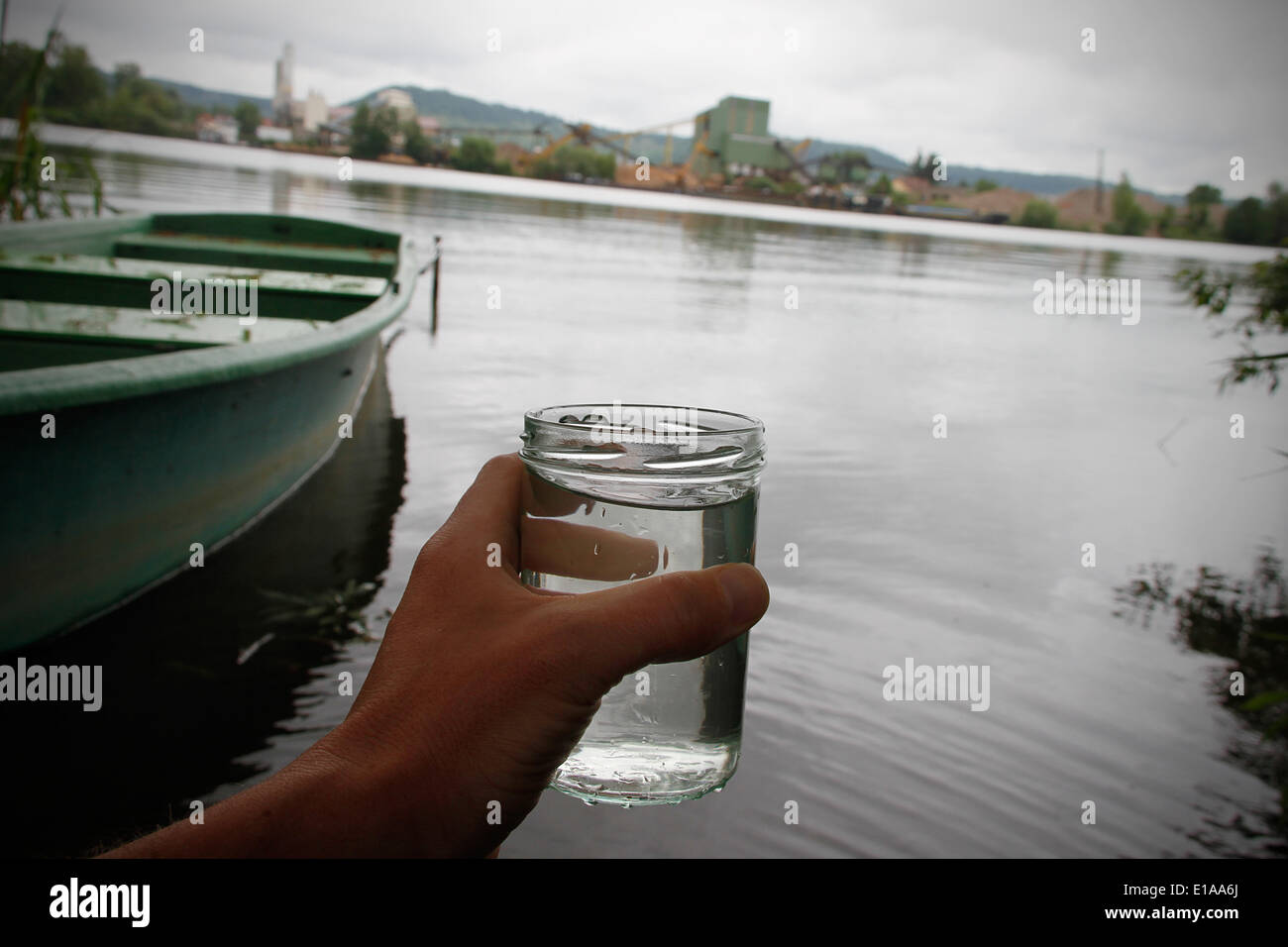 Un verre rempli d'eau du lac de Sander est représenté à la Sand am Main, Allemagne, 27 mai 2014. La qualité de l'eau de treize lieux de baignade en Allemagne a été classés comme pauvres parce que les normes de l'UE n'étaient pas respectées. Sander lac près de Hassfurt était l'un d'entre eux. Photo : RENÉ RUPRECHT/dpa Banque D'Images