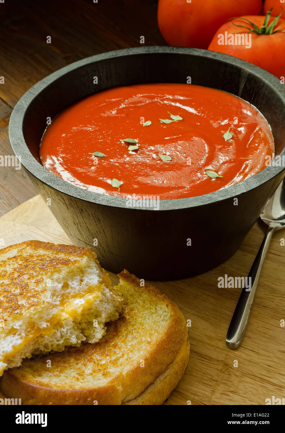 Un petit bol de soupe aux tomates faites maison et un sandwich au fromage. Banque D'Images