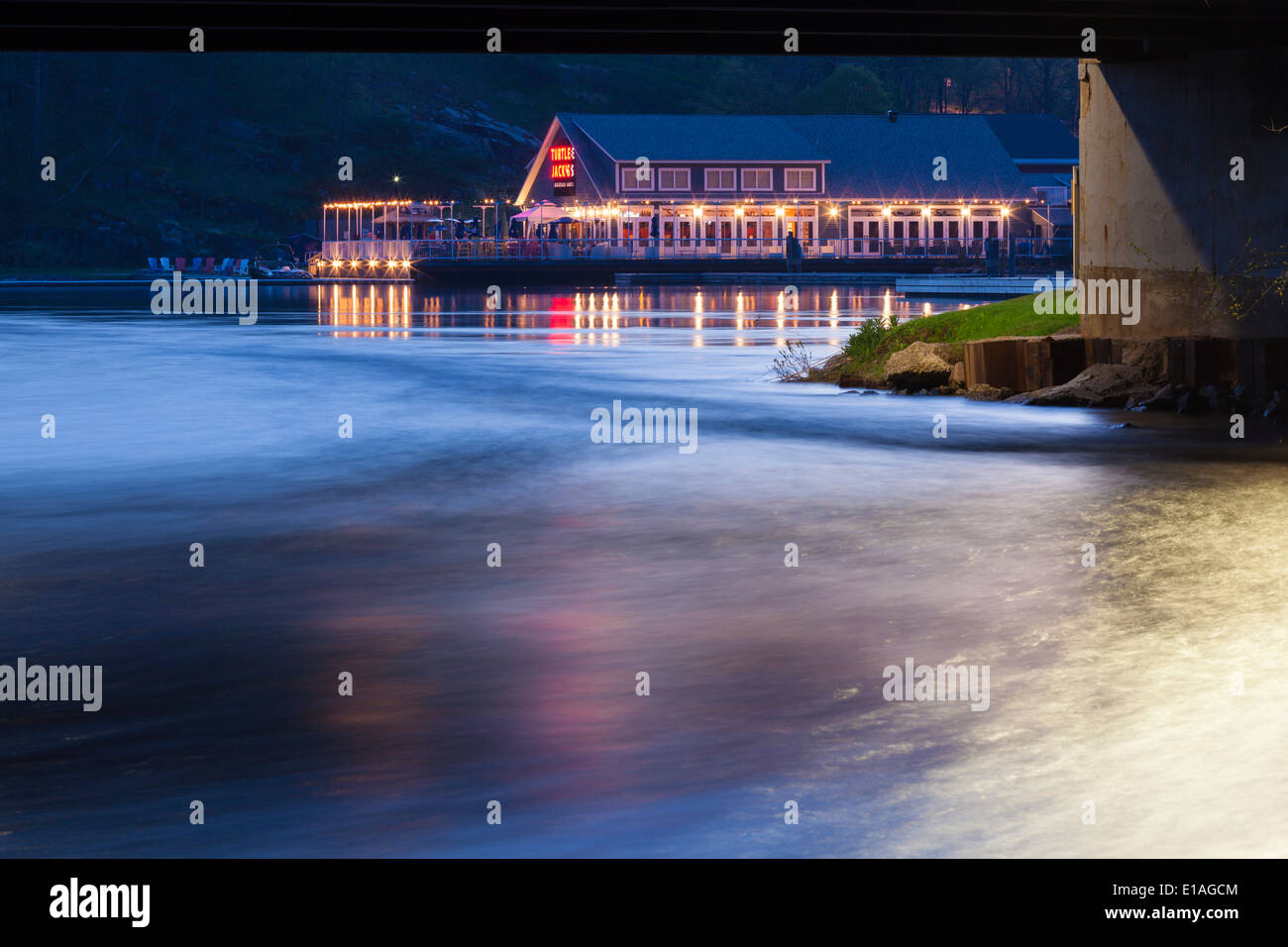 Une tortue Jacks restaurant sur la rive du lac Muskoka à la tombée de la nuit avec des lumières se reflétant dans l'eau. Port Carling Ontario, Canada Banque D'Images