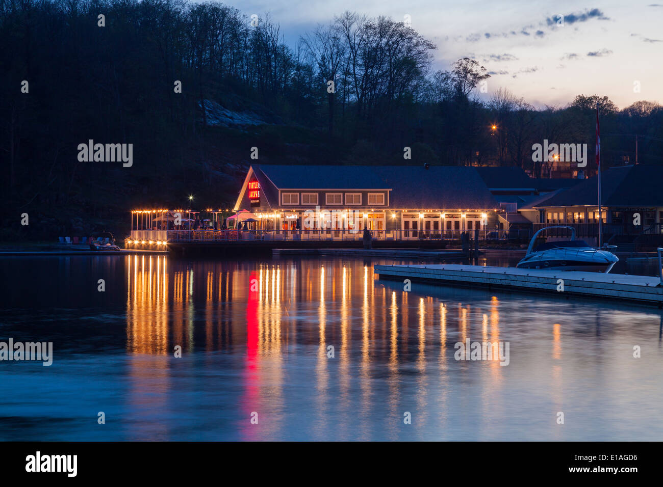 Une tortue Jacks restaurant sur la rive du lac Muskoka à la tombée de la nuit avec des lumières se reflétant dans l'eau. Port Carling Ontario, Canada Banque D'Images