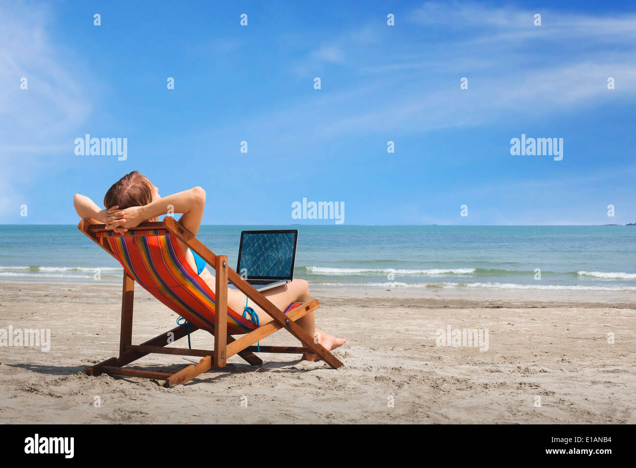Femme heureuse avec un ordinateur portable sur la plage Banque D'Images Femme heureuse avec un ordinateur portable sur la plage Banque D'Images