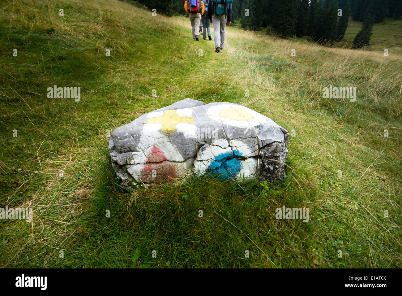 Cercle de couleur place triangulaire et les signes de randonnée sur une pierre avec des gens qui marchent sur un chemin Banque D'Images