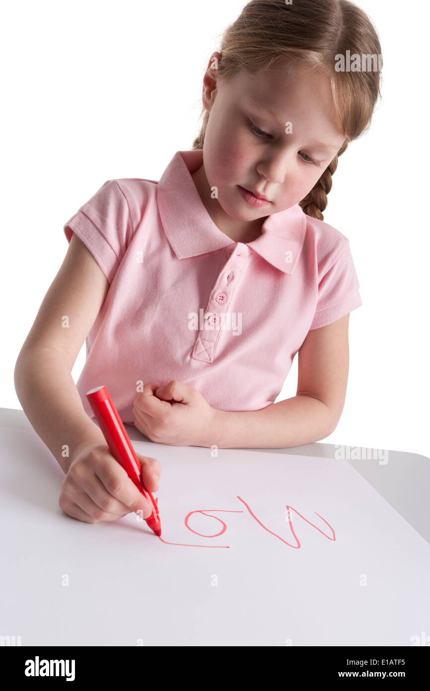 Petite fille écrivant des lettres sur fond blanc Banque D'Images
