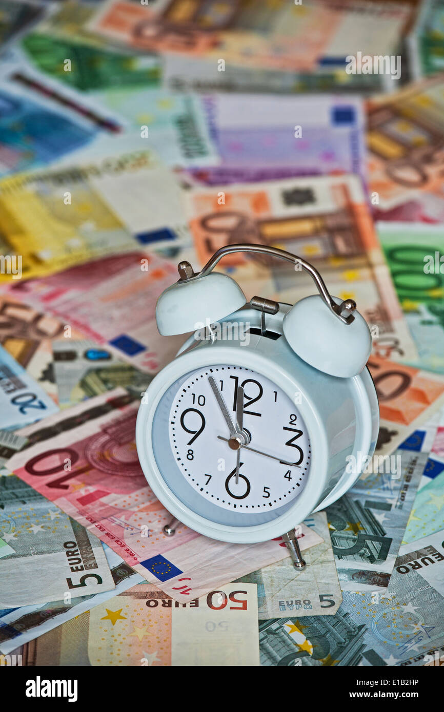 Photo montrant le temps est argent avec horloge et billets en Euro Banque D'Images