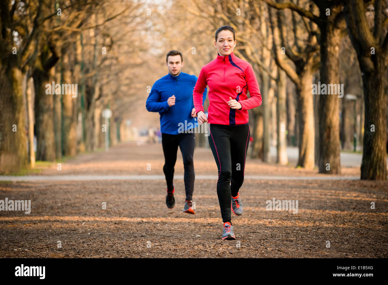 Couple jogging - jeune homme et femme de la compétition, première femme Banque D'Images