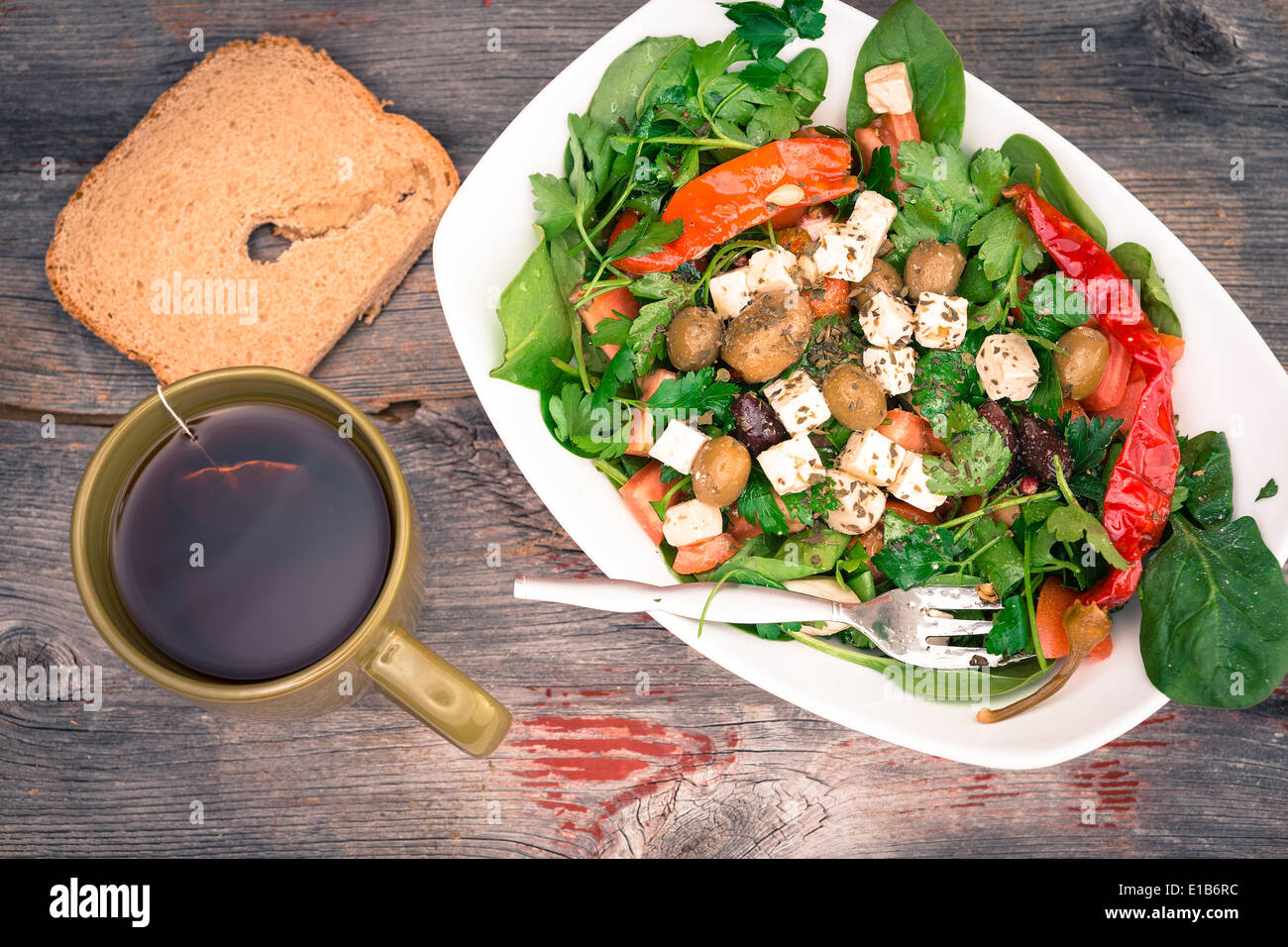 Vue de dessus d'un plat de poisson délicieux légumes verts à salade d'épinards avec du pain et du thé sur une surface en bois rustique Banque D'Images