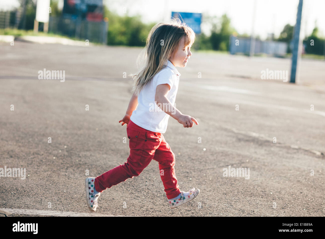 Petite fille en fuite sur la route Banque D'Images