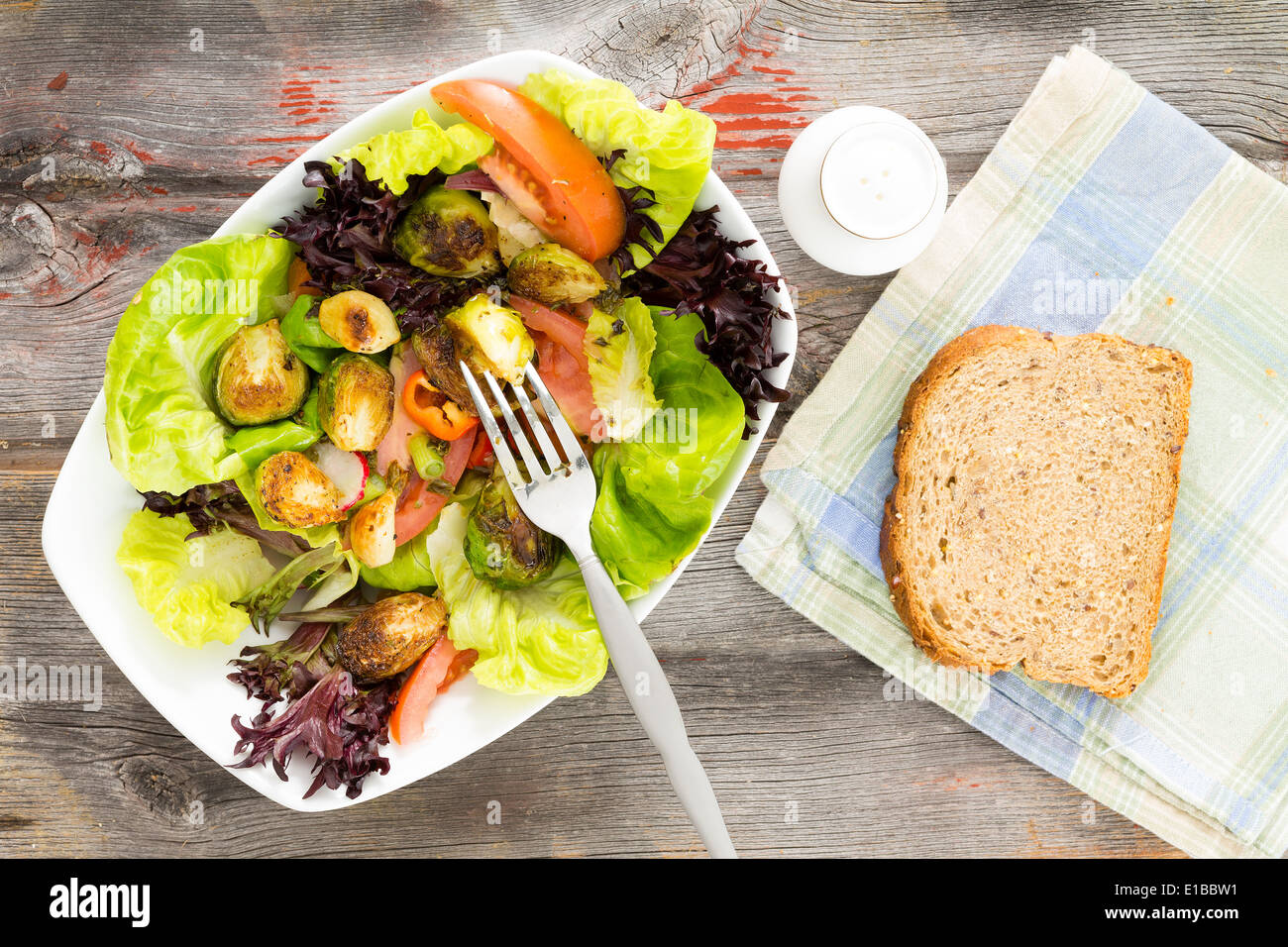 Frais délicieux légumes verts à salade mixte avec les dés et les choux de bruxelles sautés servi sur une table en bois rustique avec une tranche de Banque D'Images