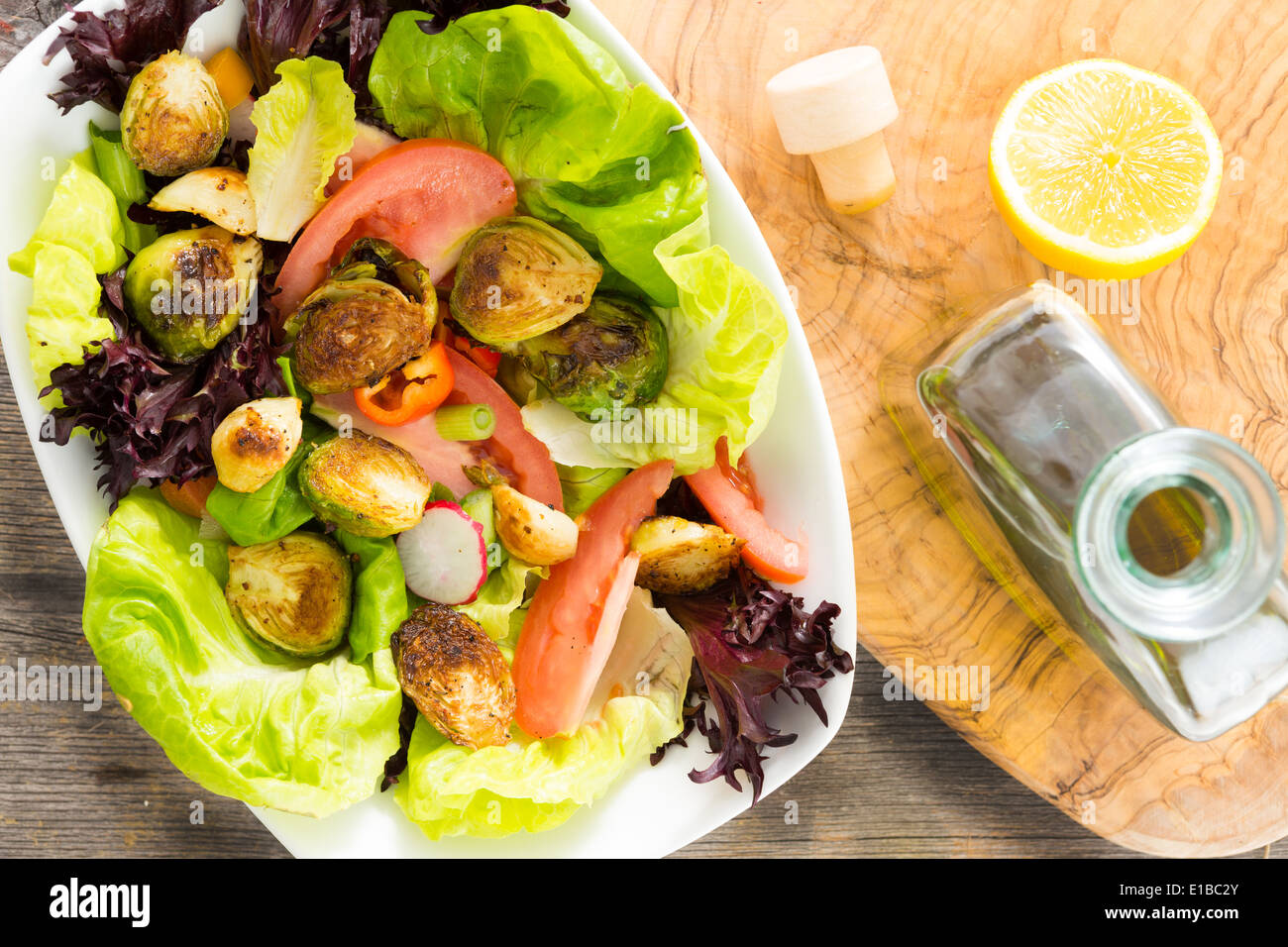 Mélange de salade de légumes verts sautés avec les choux de Bruxelles, tomates et radis arrosé d'huile d'olive vierge et citron et servi Banque D'Images