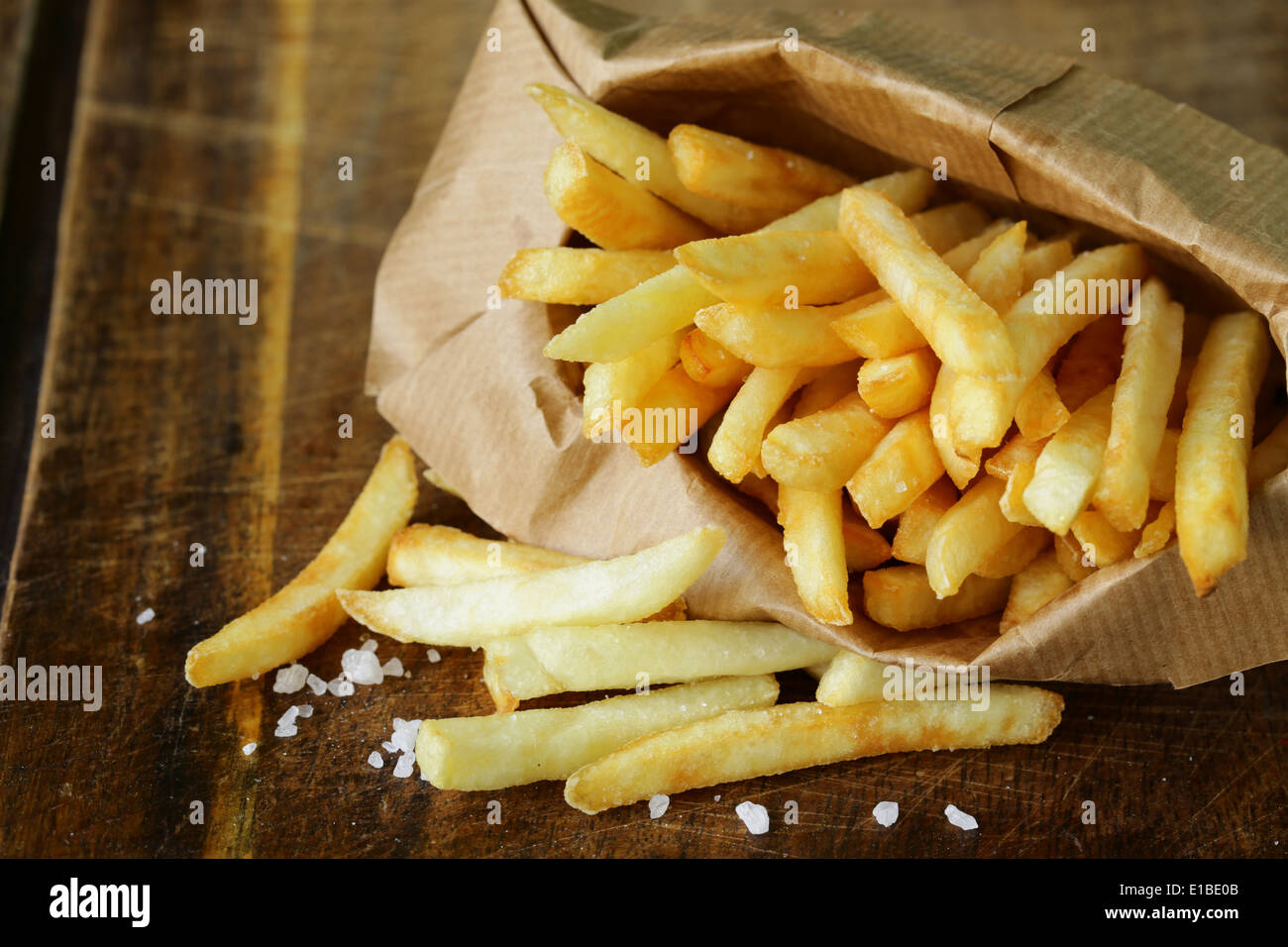 Pommes frites traditionnelles avec du sel sur fond de bois Banque D'Images