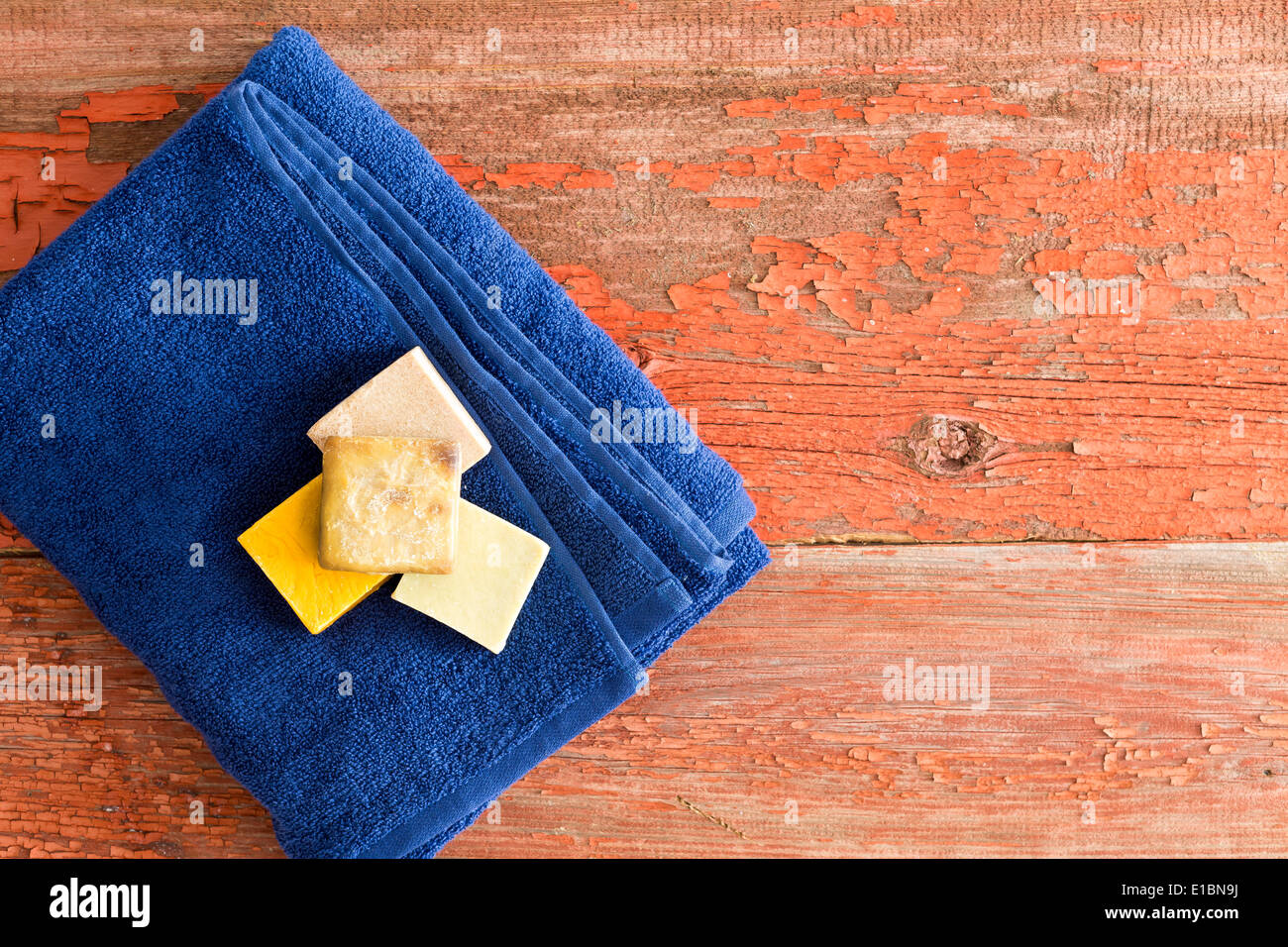 Savons bio sain sur une serviette bleu doux soigneusement plié sur planches de bois rustique dans un spa ou salon de beauté pour un soin aromat Banque D'Images