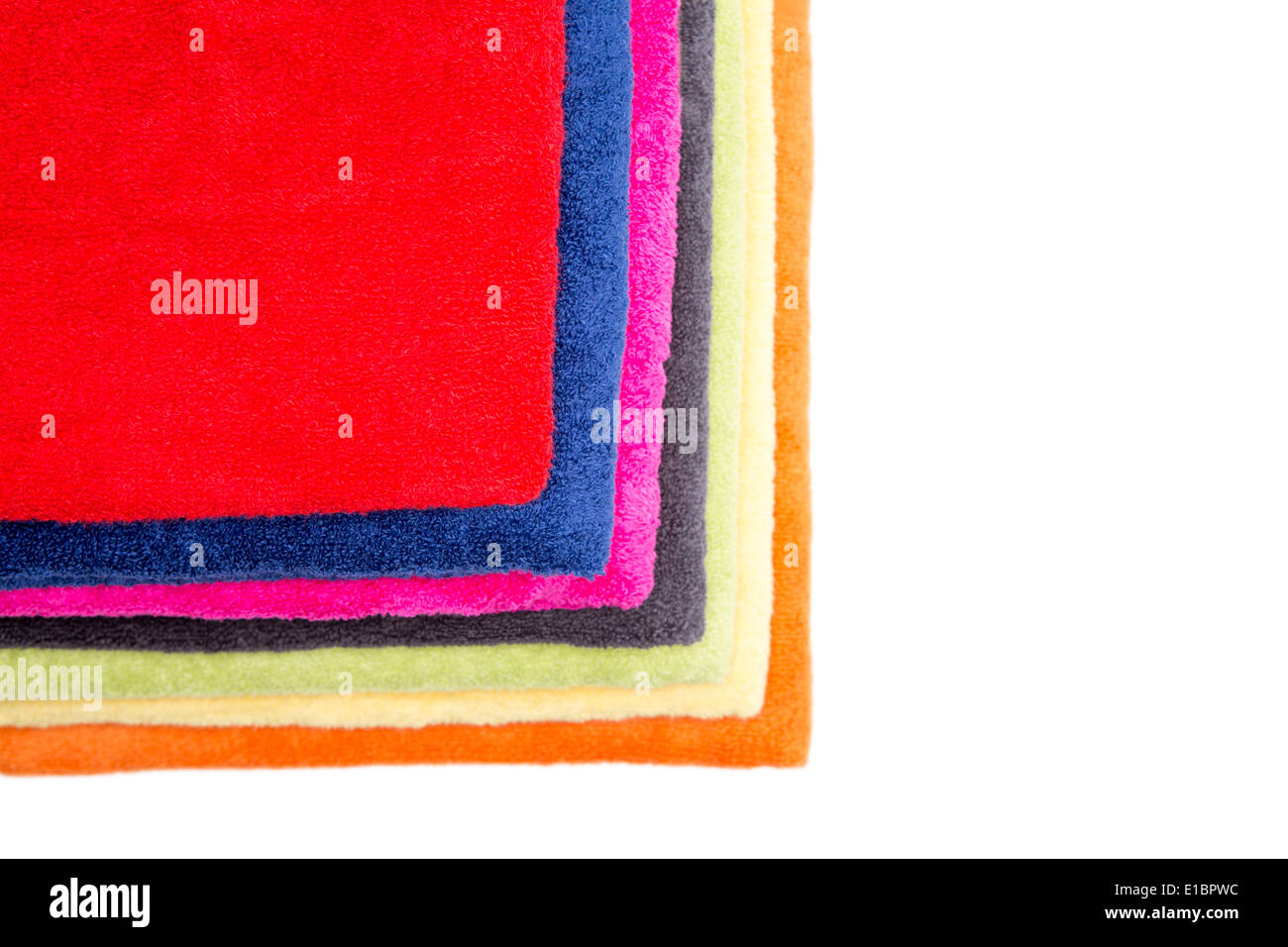 Colorful pile de serviettes moelleuses nettoyer soigneusement pliés et affiche pour montrer leurs couleurs avec un rouge sur le dessus, vu de Banque D'Images