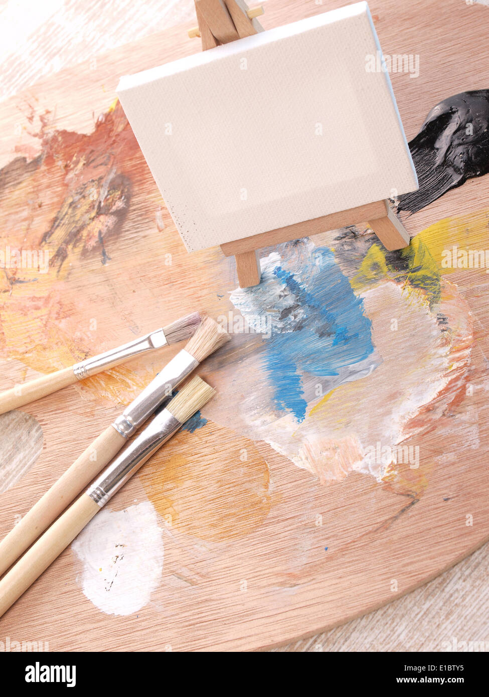 Palette de peinture avec des pinceaux et une petite toile Banque D'Images