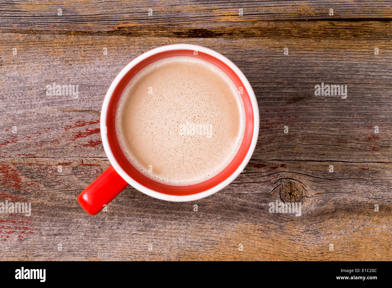 Tasse en céramique orange plein de douce chaude latte café surmonté d'une écume laiteuse , vue aérienne sur une table en bois avec copie Banque D'Images