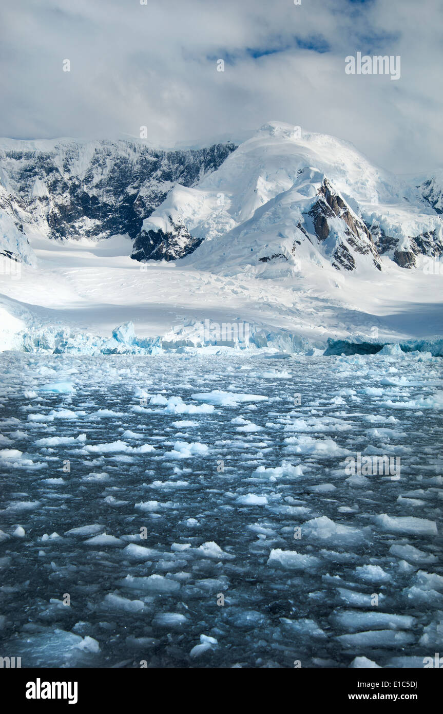Montagnes et paysages enneigés reflètent dans l'eau de mer calme. Plaques de glace sur l'eau. Banque D'Images