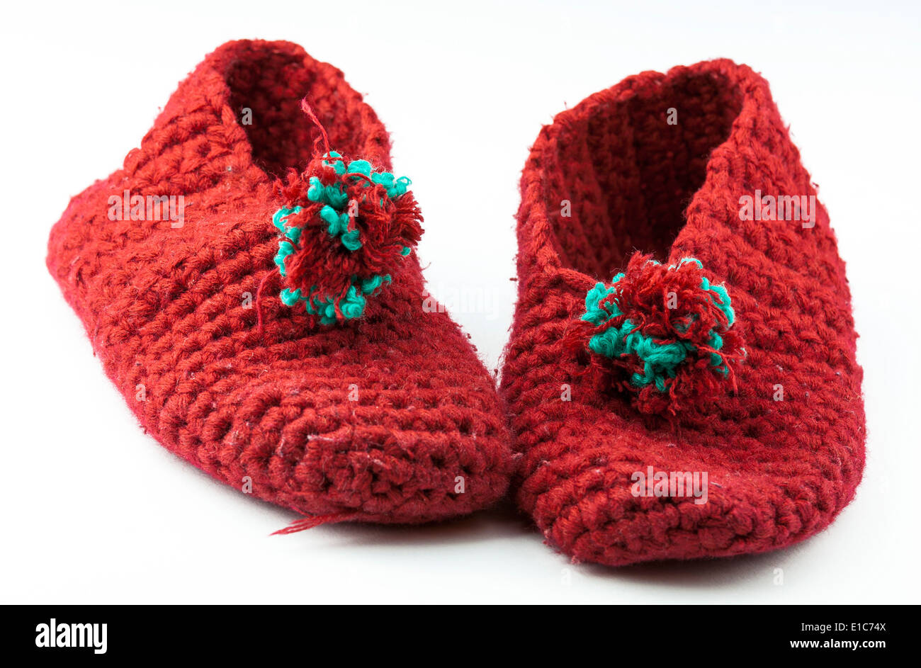 Tricoté rouge chaussons enfantin sur fond blanc Banque D'Images