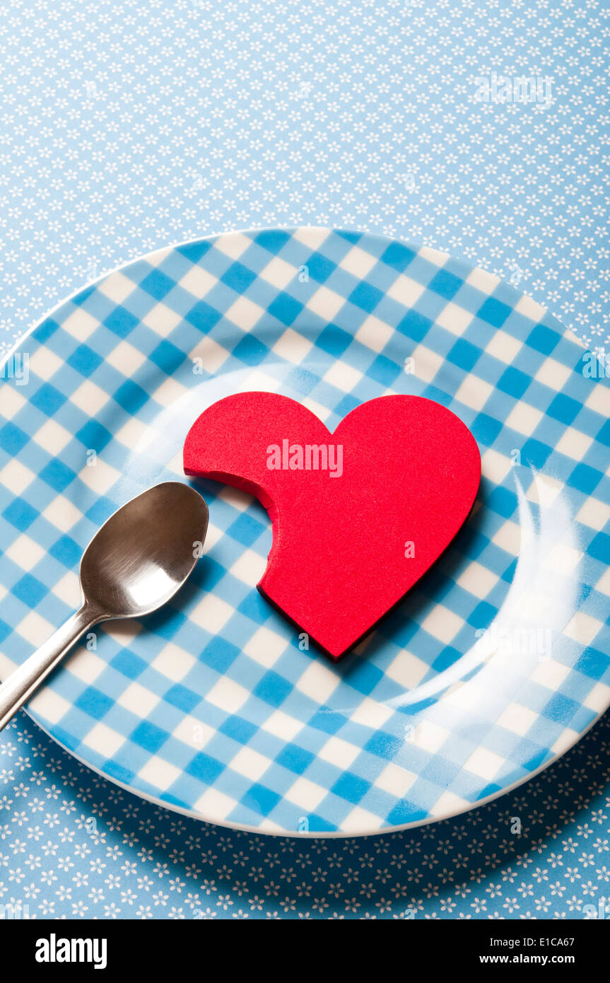 Valentine heart shape partiellement mangés sur une plaque, affamé pour love concept Banque D'Images