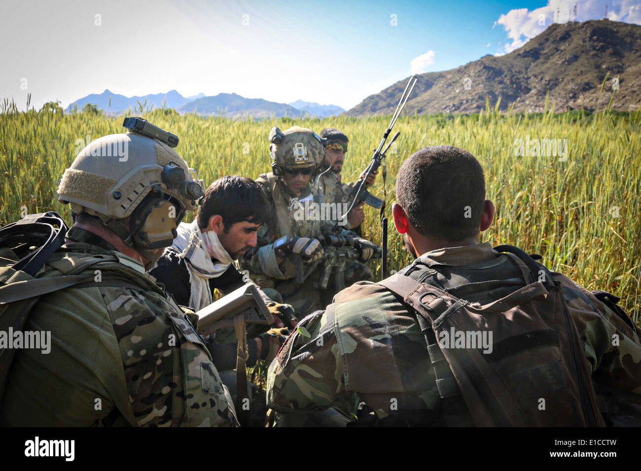 Une US Army Special Forces attendre avec une armée nationale afghane blessés commando des forces spéciales pour l'évacuation médicale par hélicoptère à la suite d'un échange de tirs avec des insurgés talibans 27 mai 2014 dans le district de Nejrab, la province de Kapisa, en Afghanistan. Banque D'Images