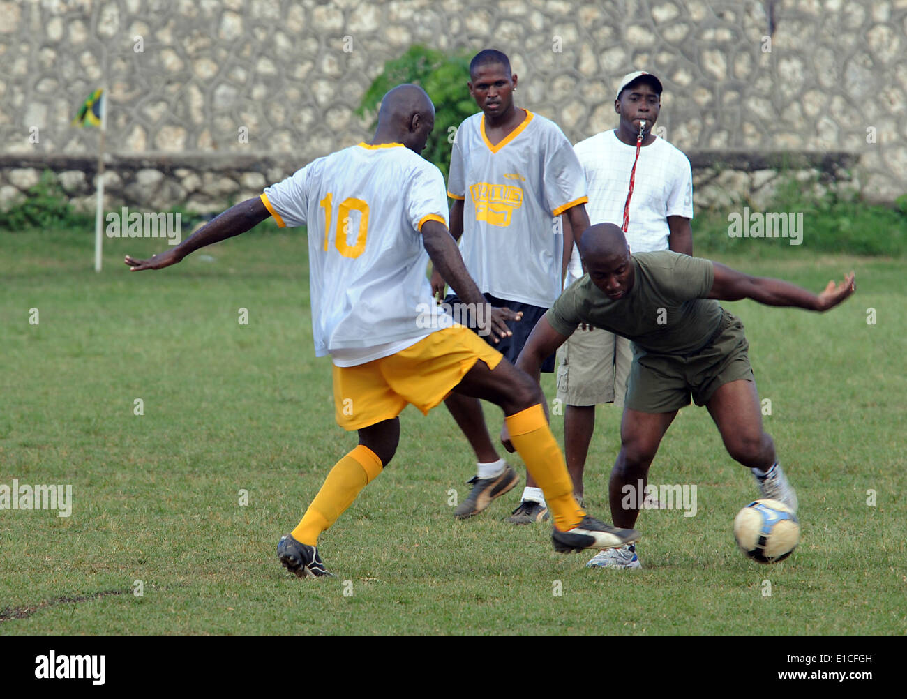 Le sergent d'artillerie du Corps des Marines des États-Unis. Gaw manoeuvres Jones un ballon de foot autour d'un adversaire pendant un match de football amical contre Irie Banque D'Images