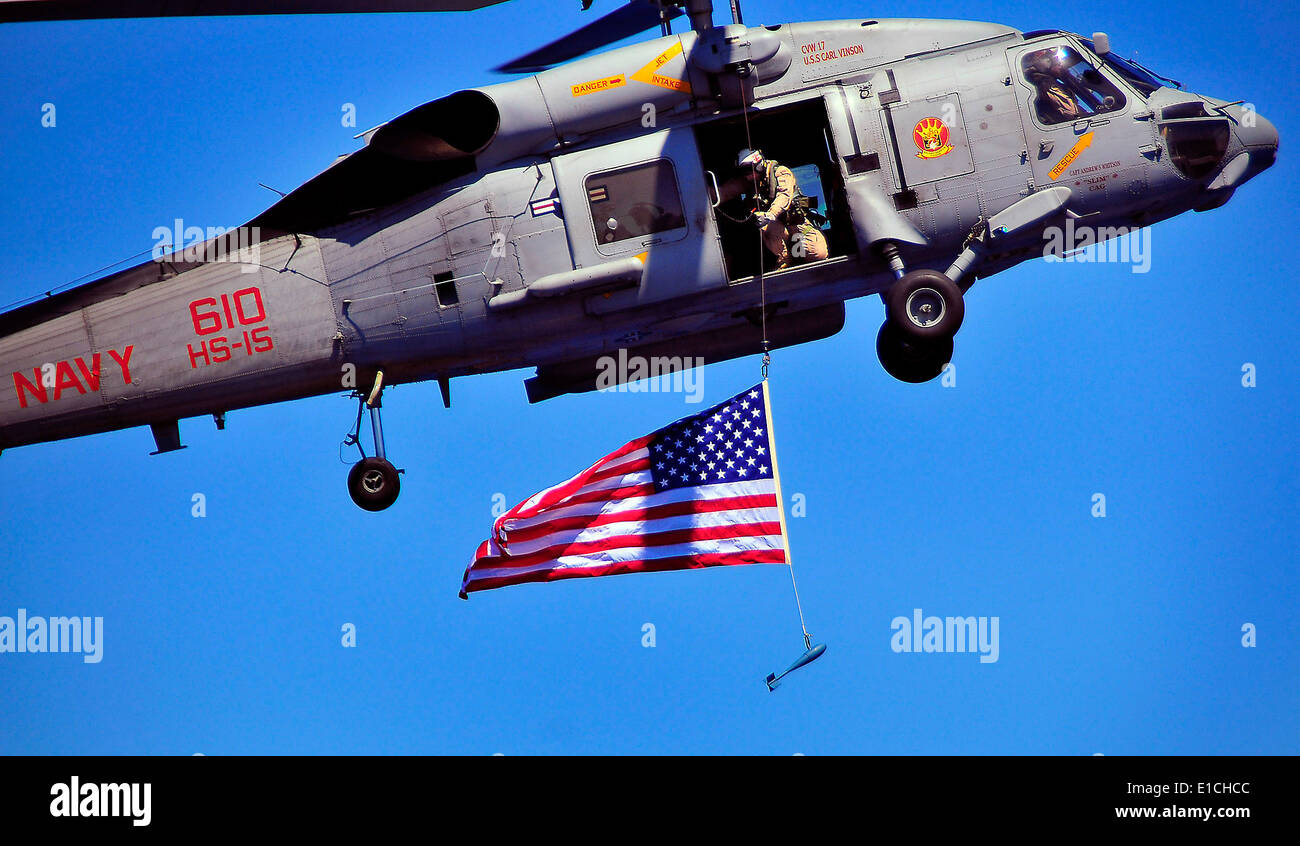 Un marin américain à partir de la neutralisation des explosifs et de l'unité mobile 3 suspend un drapeau américain à partir d'un hélicoptère Seahawk SH-60F au cours de Banque D'Images