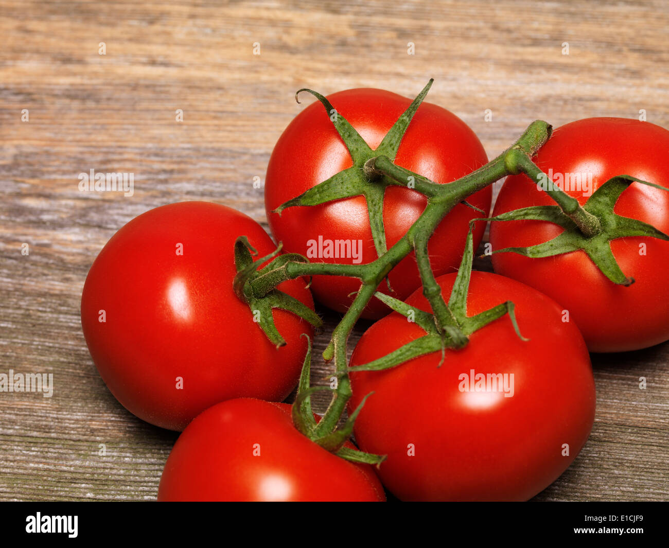 Gros plan sur la vigne tomates sur fond de table en bois rustique Banque D'Images