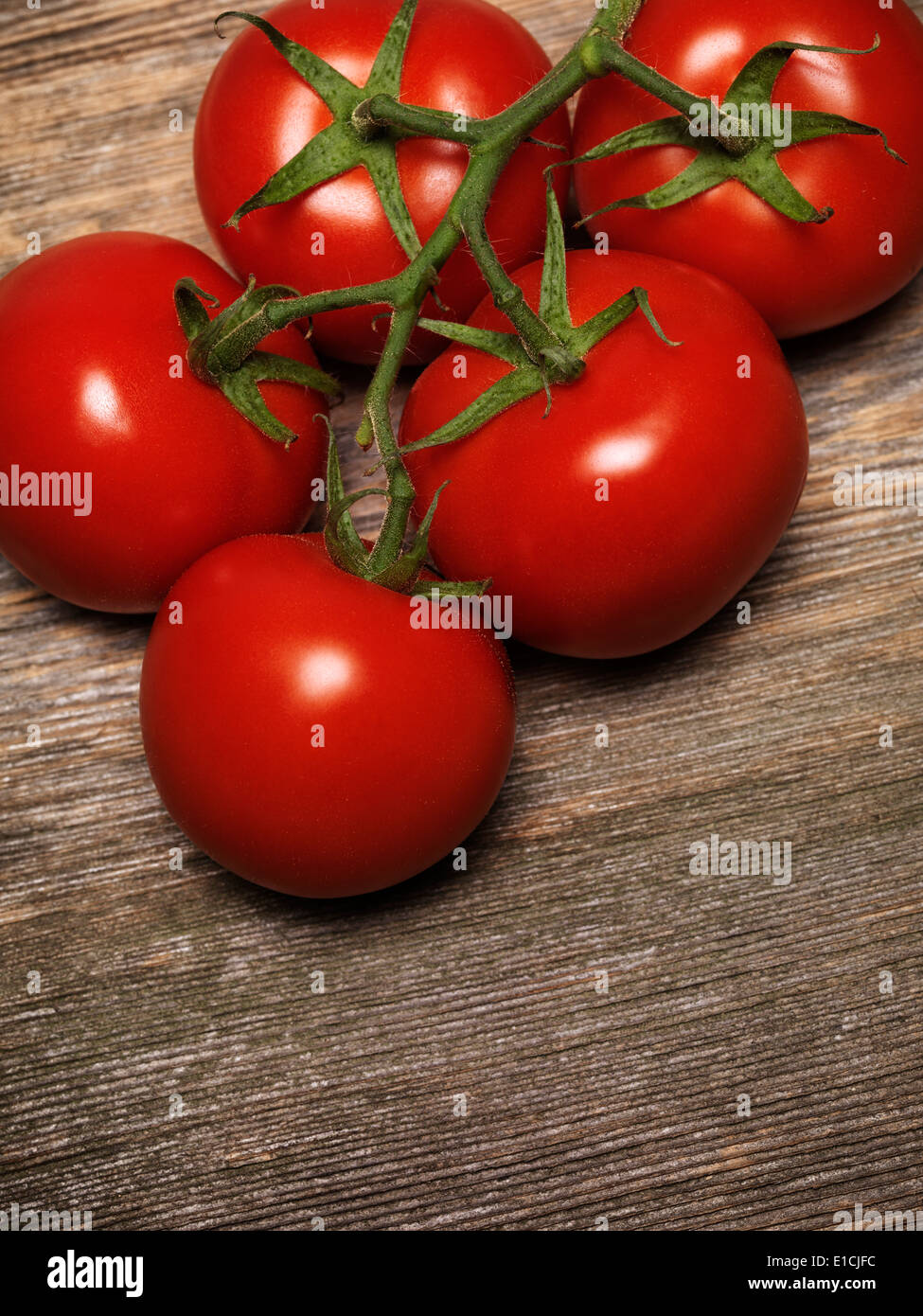 Gros plan sur la vigne tomates sur fond de bois rustique Banque D'Images