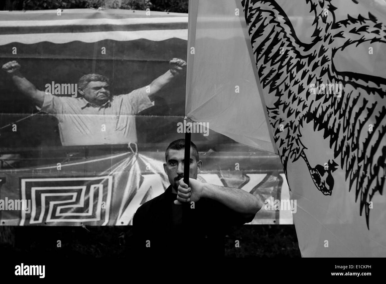Athènes, Attique, Grèce. 29 mai, 2014. Un membre du parti tenant un drapeau byzantin avec un aigle à deux têtes en face de la photo du chef du parti Nikolaos Michaloliakos, lors d'un événement organisé par le parti nationaliste Aube dorée en face de la cathédrale d'Athènes, à l'occasion de l'anniversaire de la chute de Constantinople aux mains des Turcs, le mai 1453. Dans le centre d'Athènes le 29 mai 2014 © Panayiotis Tzamaros/NurPhoto ZUMAPRESS.com/Alamy/Live News Banque D'Images