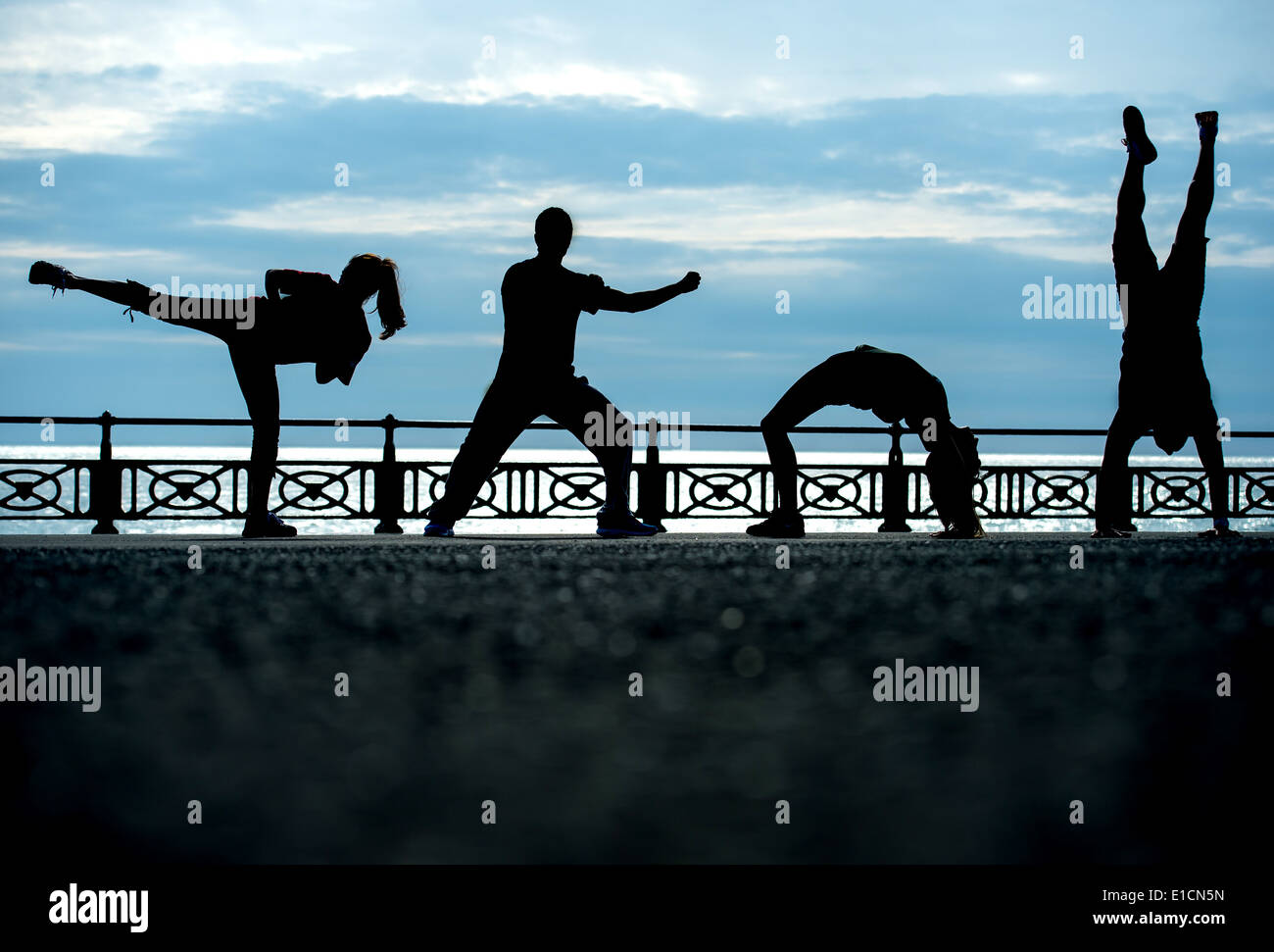 Boxercise personnel qui sont formés dans les arts martiaux de poser dans les différentes positions de l'art martial et sportif au coucher du soleil à Brighton Banque D'Images