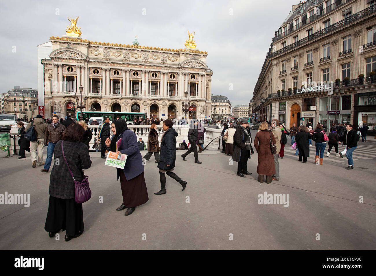 Une gitane à vendre des journaux pour les personnes de passage dans une scène de rue, Paris. Banque D'Images