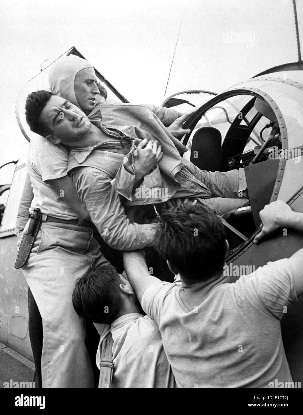 Un ascenseur de l'équipage blessés hors de son pilote Grumman TBF Avenger. Il est retourné à le porte-avions USS Saratoga après un raid sur Banque D'Images