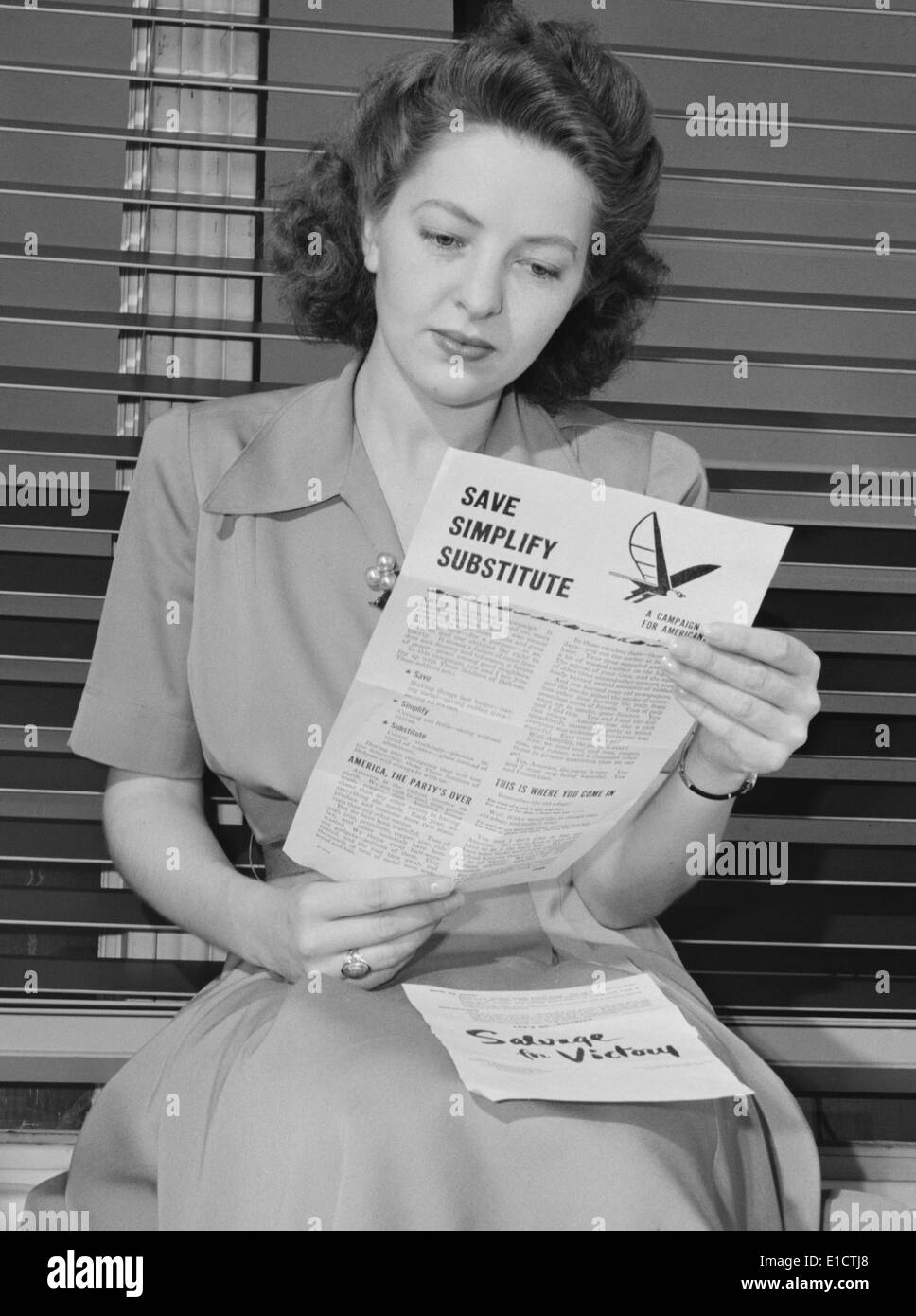 American Woman lit une brochure du gouvernement sur intitulé 'Save, simplifier, succédané". Il a expliqué pourquoi le sucre était rationné, et pourquoi Banque D'Images