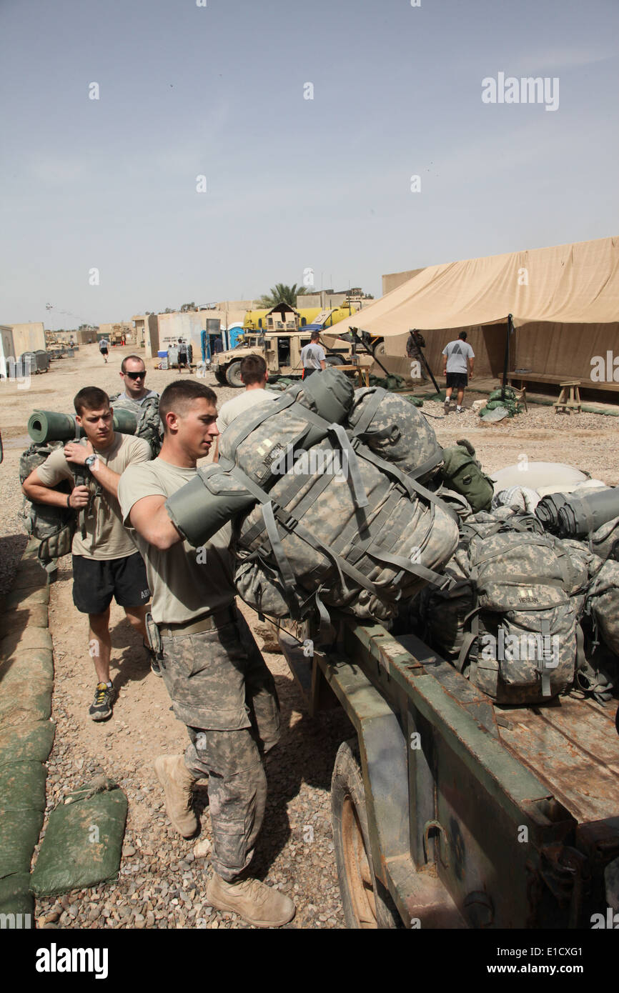 Des soldats américains charger une remorque avec des sacs à dos tout en se préparant à son tour la sécurité du Site commun Shaura Jidr Um à Bagdad, l'Iraq, plus t Banque D'Images