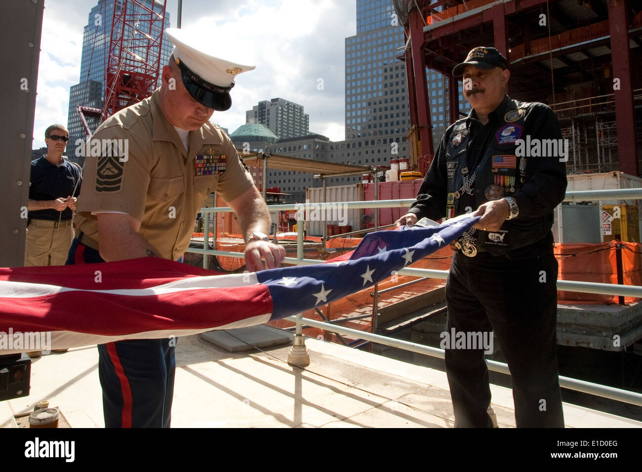 NEW YORK -- Maître Marin Sgt. William Gibson, Jr, permet de replier un drapeau américain, après qu'il a survolé le World Trade Center const Banque D'Images