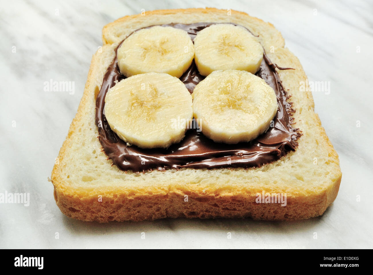 Le pain avec des tranches de banane et de crème au chocolat Banque D'Images
