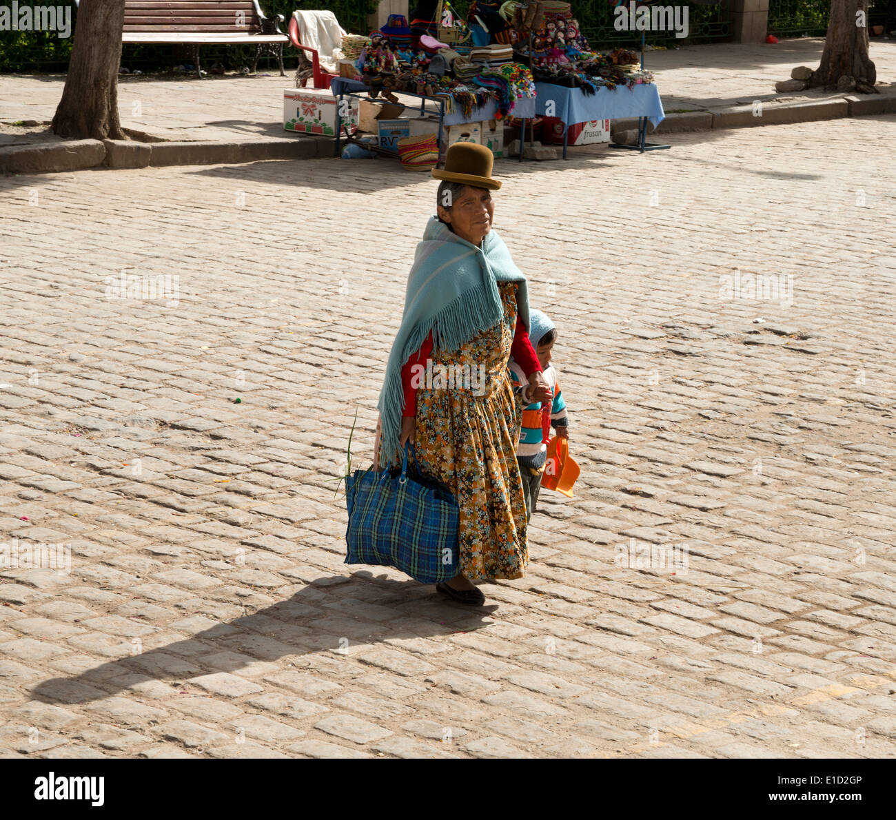 Cholita femme et enfant traversant un carré à Copacabana, Bolivie Banque D'Images