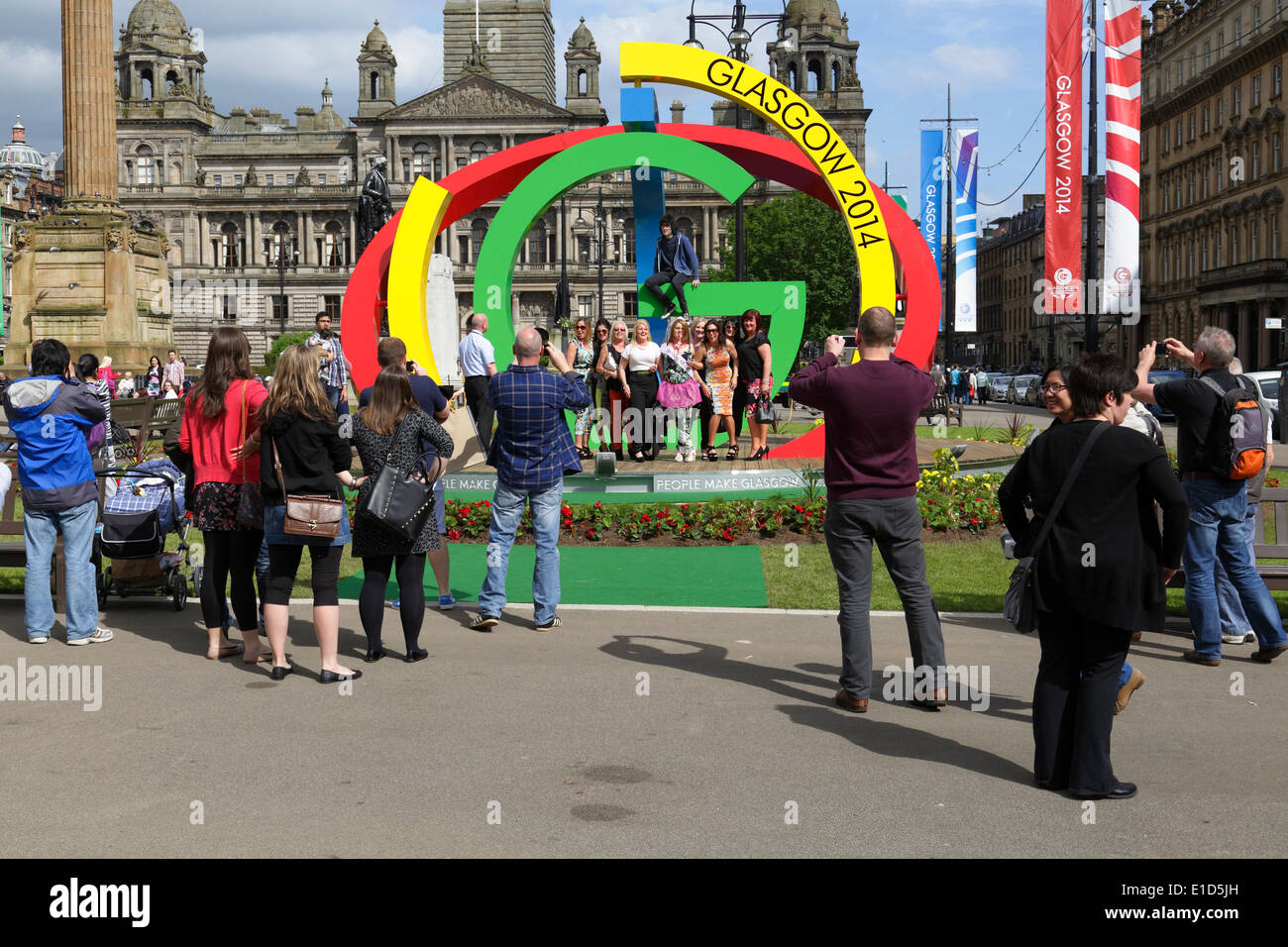 George Square, Glasgow, Écosse, Royaume-Uni, samedi 31 mai 2014. Glasswegians et visiteurs prenant des photos des Jeux du Commonwealth de Glasgow 2014 logo The Big G dans le centre-ville Banque D'Images