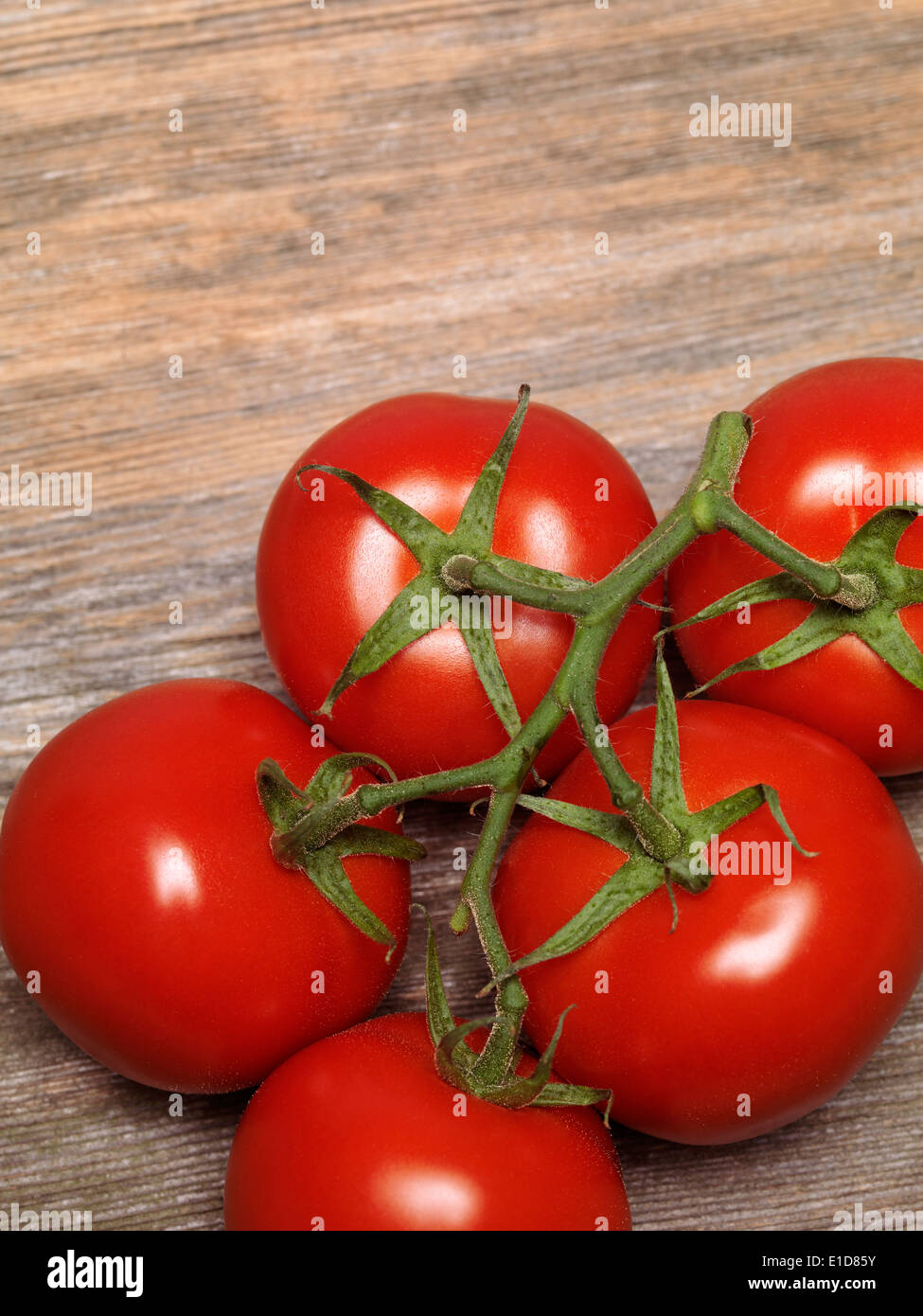 Tomates grappes mûres sur le fond de bois rustique Banque D'Images