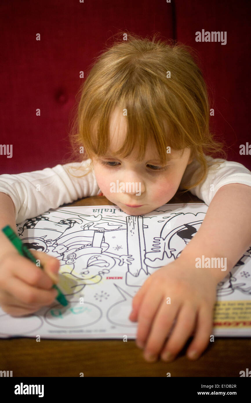 4 quatre ans, fille, et le dessin et le coloriage de avec des crayons Banque D'Images