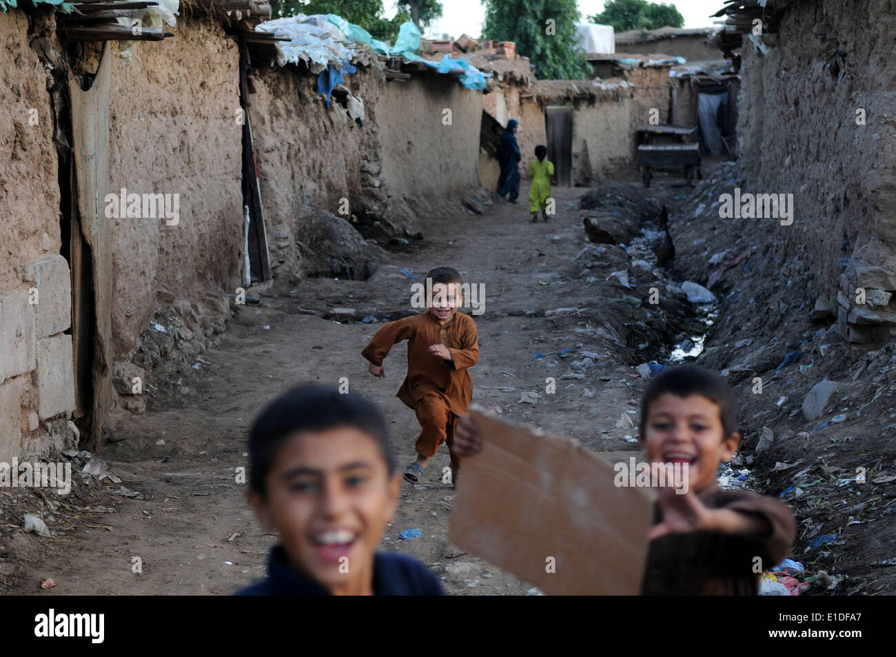 Islamabad, Pakistan. 1er juin 2014. Un réfugié afghan boy fonctionne sur une sale allée sur la la Journée internationale de l'enfant à un bidonville à la périphérie d'Islamabad, capitale du Pakistan, le 1er juin 2014. Selon le gouvernement pakistanais et le HCR, en ce moment plus de 1,6 millions de réfugiés afghans au Pakistan vivent en mauvais état. Credit : Ahmad Kamal/Xinhua/Alamy Live News Banque D'Images