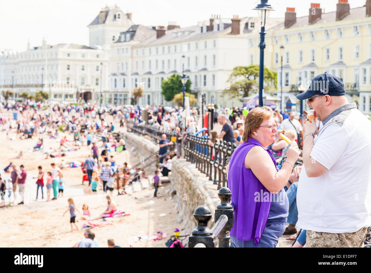 Les vacanciers appréciant un cornet de crème glacée et la glace sucette, à la plage, la promenade de Llandudno, au nord du Pays de Galles, Grande-Bretagne, Banque D'Images